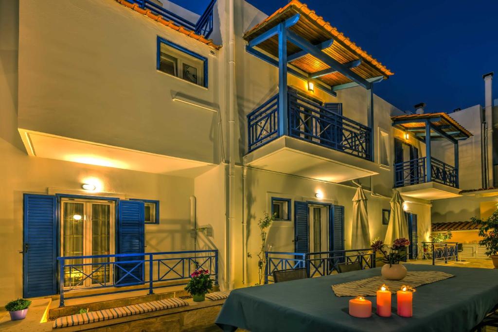 a white building with blue balconies and a table with candles at Elegant 1BR by Heraklion Beach Sun &Comfort Await in Amoudara Herakliou