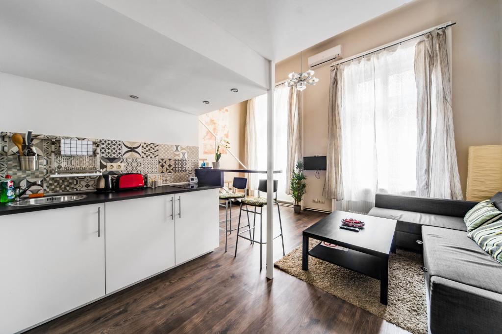 ブダペストにあるErzsébet Apartmanokのキッチン、リビングルーム(ソファ、テーブル付)