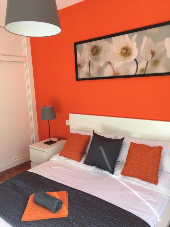 - une chambre dotée d'un lit avec un mur orange dans l'établissement 8 Beach Villas Casa Tomas, à Caleta de Fuste