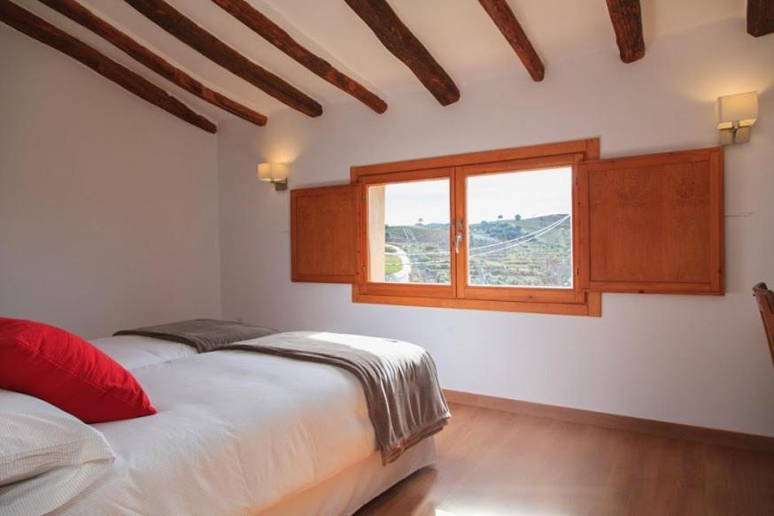 a bedroom with two beds and a window at Clos Figueras in Gratallops