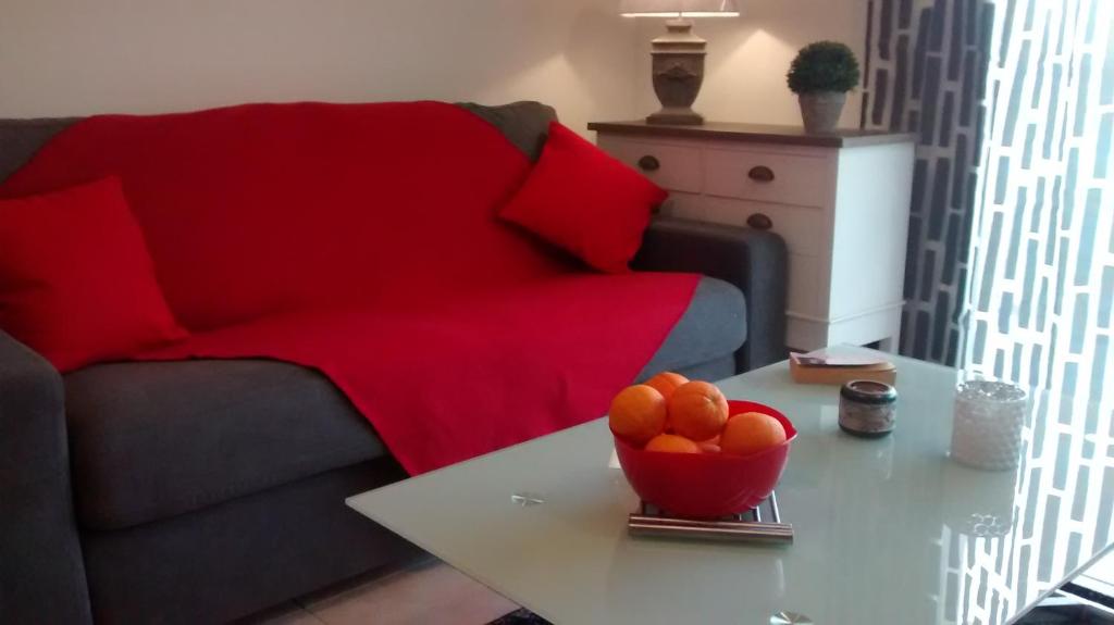 ein Wohnzimmer mit einem Sofa und einer Schüssel Orangen auf dem Tisch in der Unterkunft Victoria in Calvi