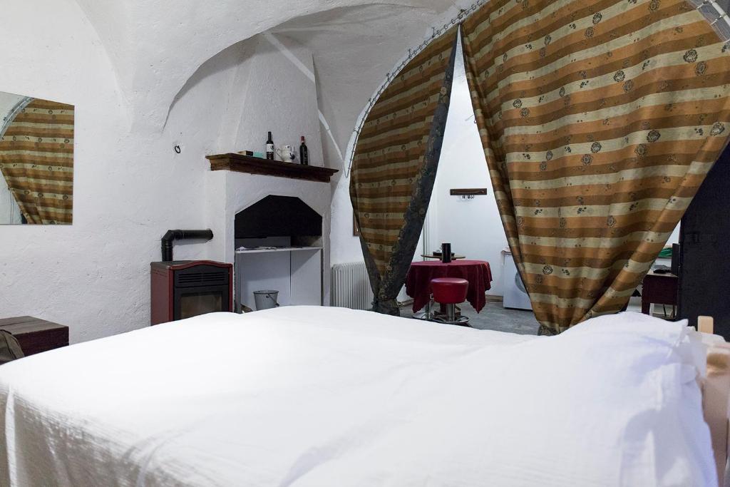 a bedroom with a white bed and a fireplace at La stufa rossa in Sondrio