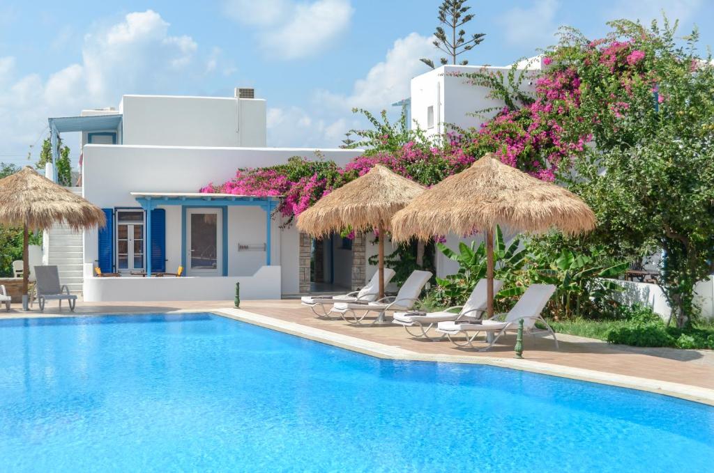 a villa with a swimming pool with chairs and umbrellas at Aggeliki's Diamond in Agia Anna Naxos