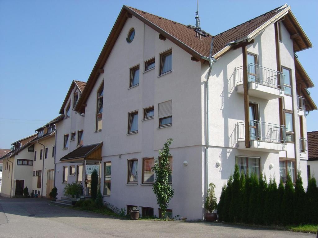 a white building with a brown roof at Hotel Dietz in Allmendingen