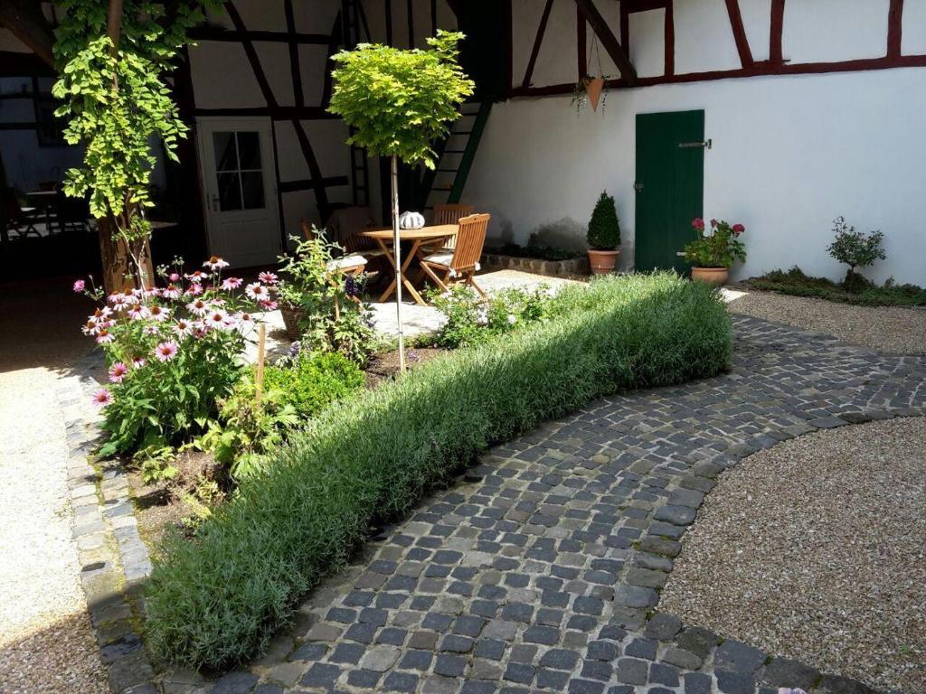 a garden with a hedge in front of a building at Ferienhaus-Loehndorf in Sinzig
