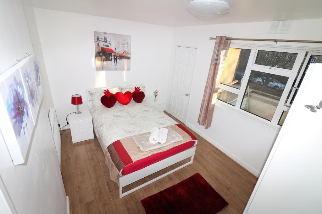 ロンドンにあるMordern/Luxary 2 BED Flat Near Central Londonの白い小さなベッドルーム(赤い枕のベッド付)