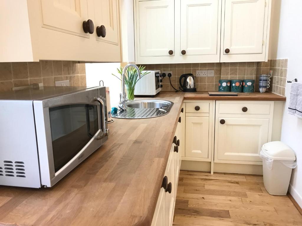 a kitchen with a microwave and a sink at The Annex - Penzance town centre with parking in Penzance