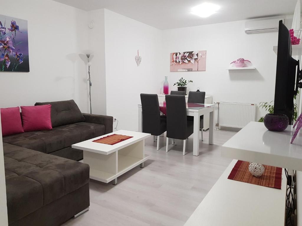 - un salon avec un canapé et une table dans l'établissement Apartment GEA 18, à Novi Sad