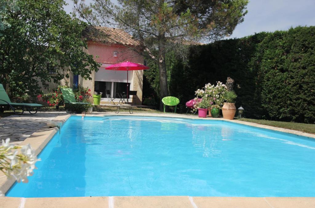 une grande piscine bleue en face d'une maison dans l'établissement ENTRE AVIGNON et PONT DU GARD, à Rochefort-du-Gard