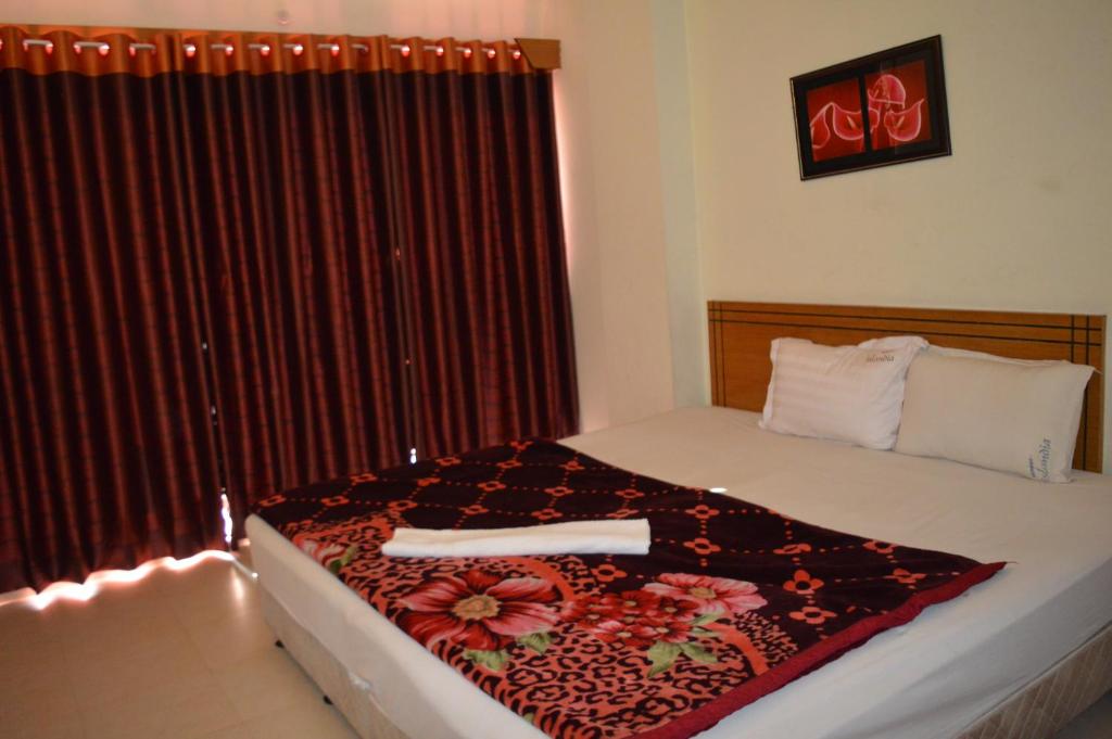 a bedroom with a bed with a red curtain at Resort Islandia in Cox's Bazar
