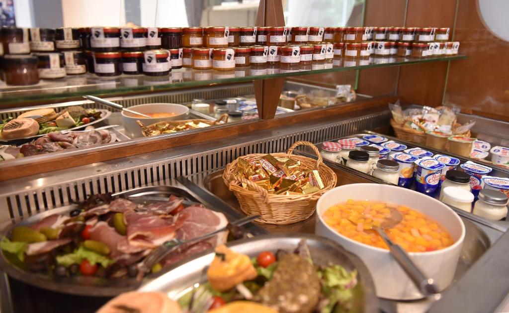 um buffet cheio de muitos tipos diferentes de alimentos em Hotel Arena restaurant le Refuge em Corte