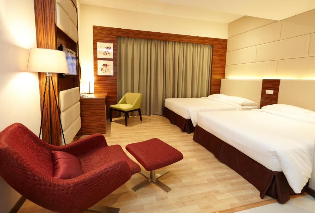 een hotelkamer met 2 bedden en een stoel bij Hotel Six Seasons @ Mid Valley in Kuala Lumpur