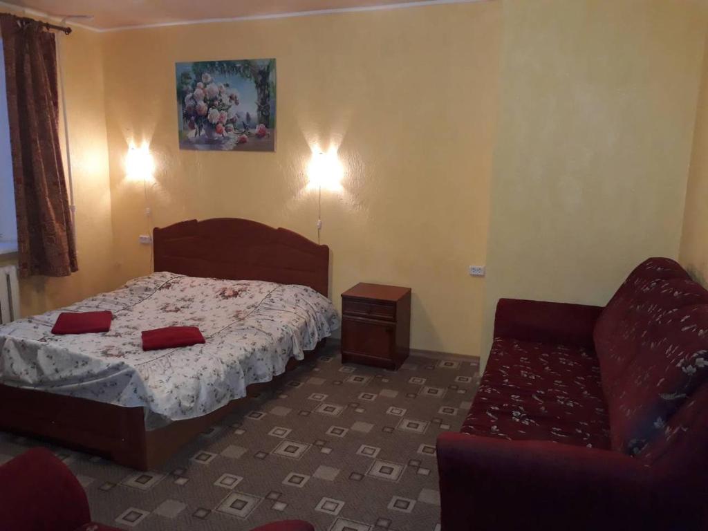 a bedroom with a bed and a chair at Hotel Europlus in Poltava