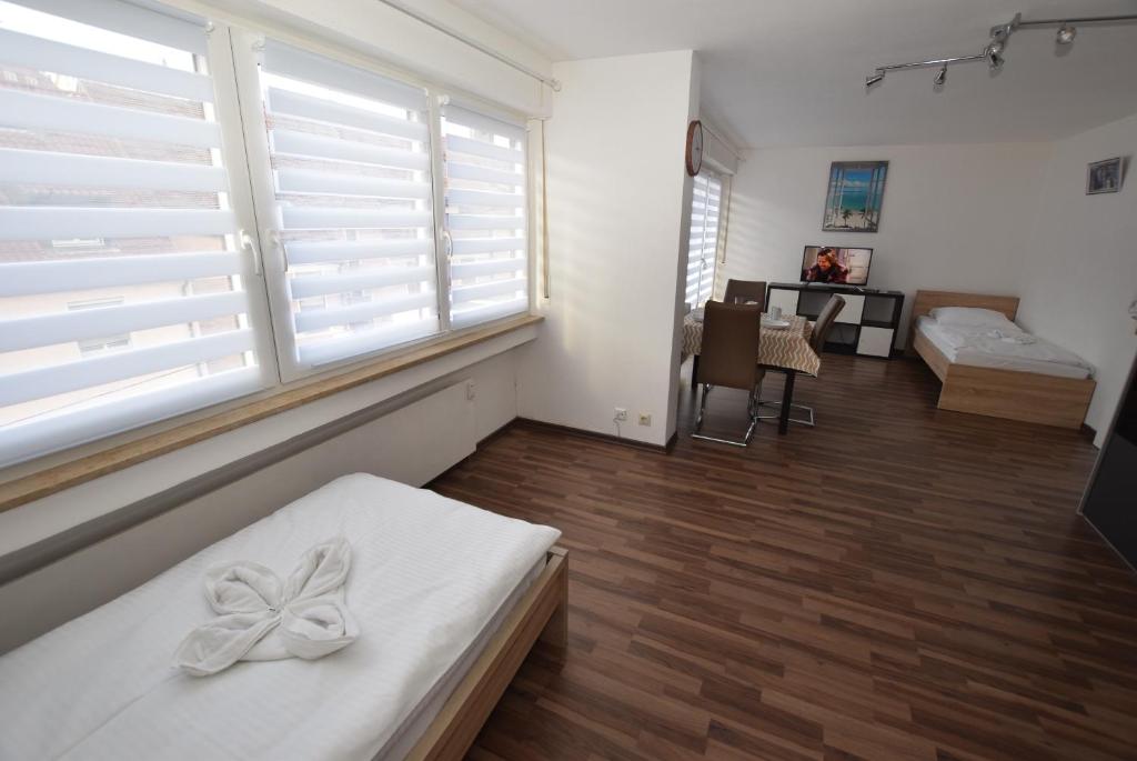 a room with white shuttered windows and a bed with a bow at Apartment Gablenberg in Stuttgart