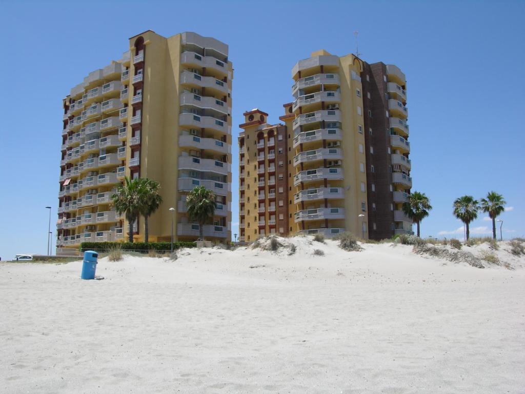 dos edificios altos en la playa con palmeras en Playa Principe - 6507, en La Manga del Mar Menor
