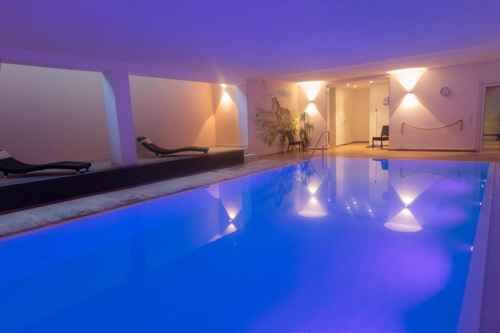Hotel Zum Löwen في مورفلدن فالدورف: حمام سباحة مع أضواء زرقاء في الغرفة