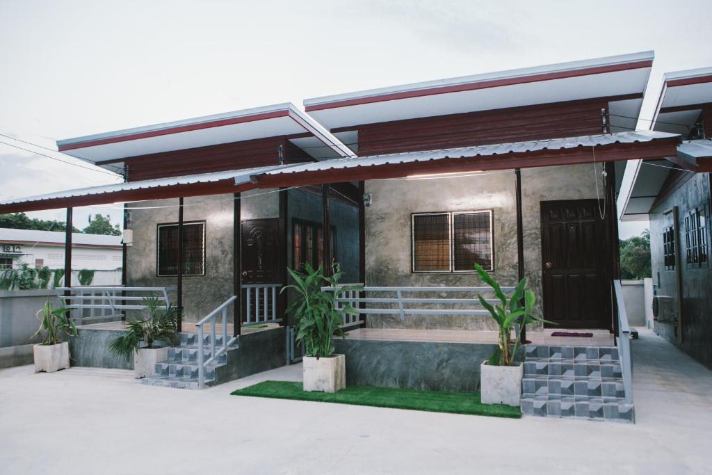 un edificio con plantas delante de él en ฺBaan Tonglong Homestay en Hang Dong