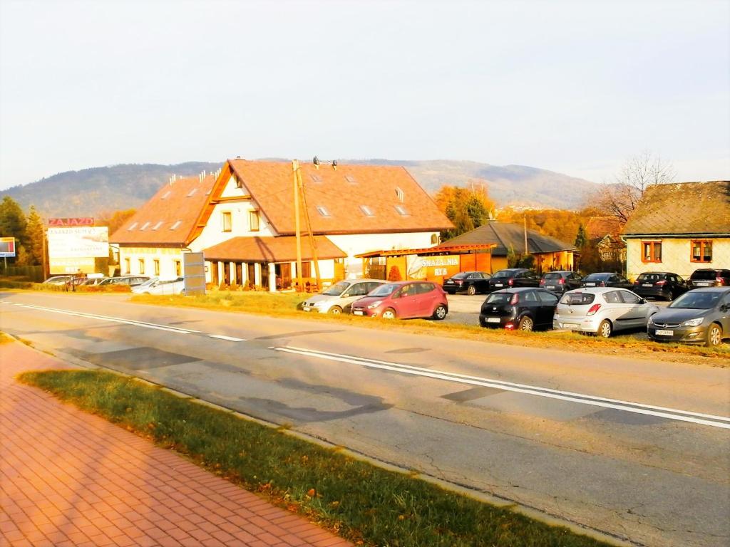 een straat met auto's geparkeerd aan de kant van een weg bij Zajazd Sum in Szczyrk