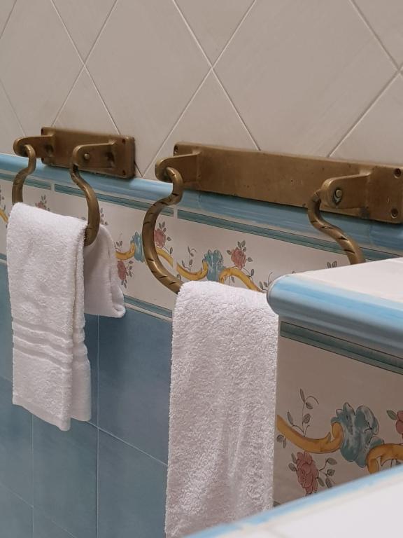 deux serviettes suspendues à un support dans une salle de bain dans l'établissement La Limonaia e La Praia, à Praiano