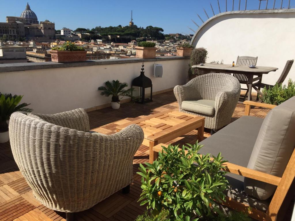 a patio with chairs and a table on a roof at Penthouseinrome in Rome