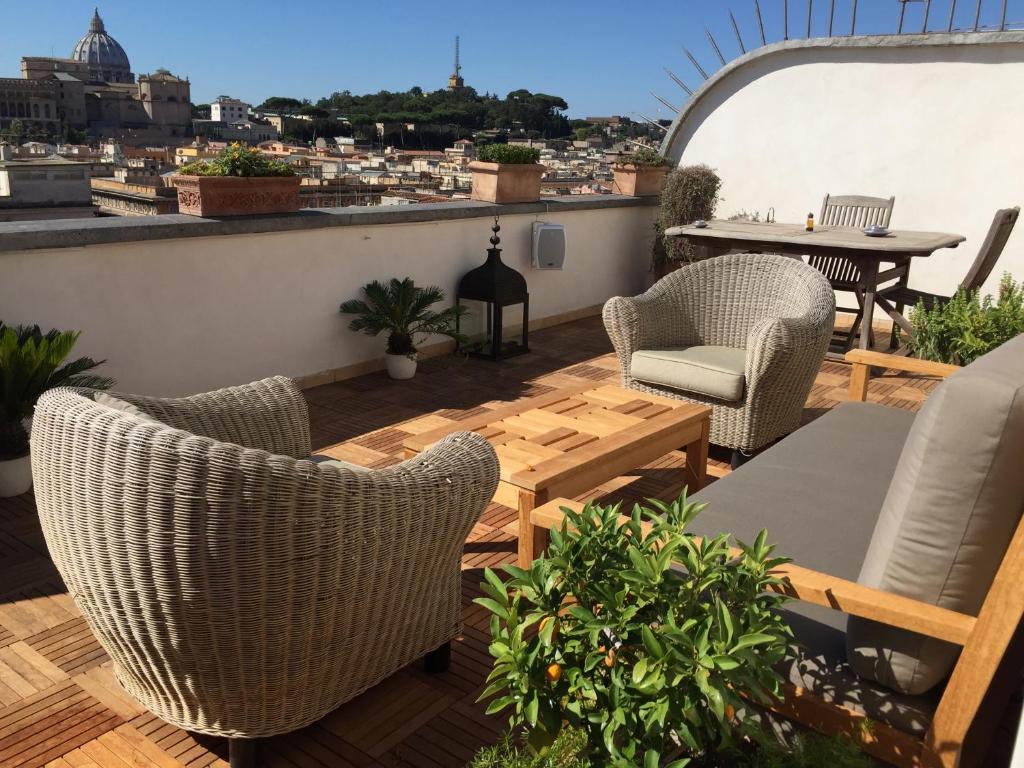 un patio avec des chaises et une table sur le toit dans l'établissement Penthouseinrome, à Rome