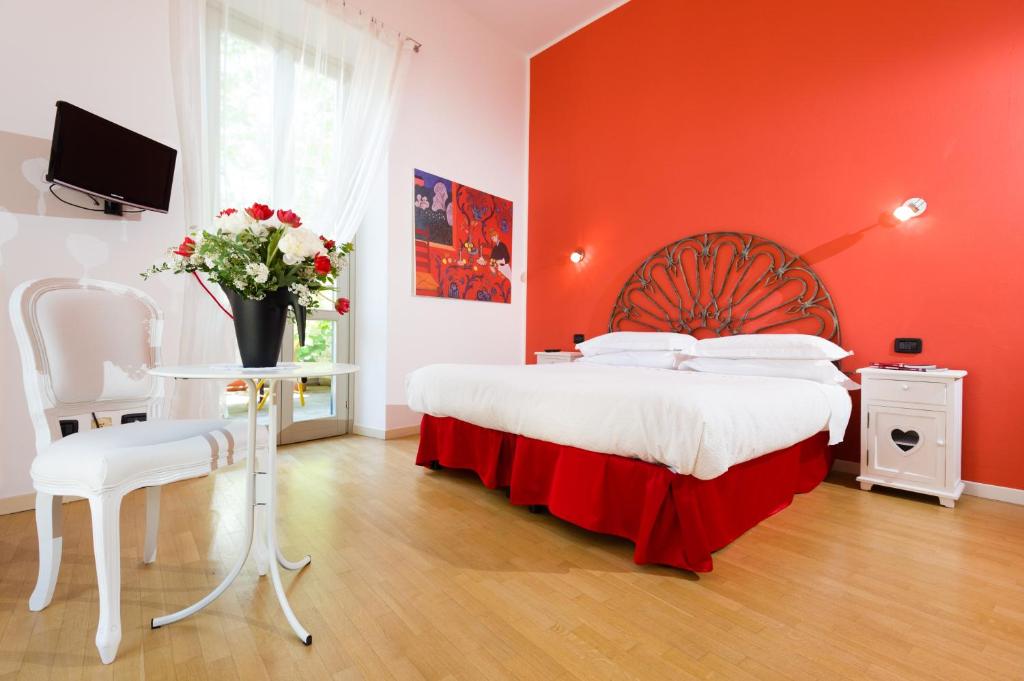 ベルガモにあるBergamo Sottosopraの赤い壁のベッド付きの赤いベッドルーム