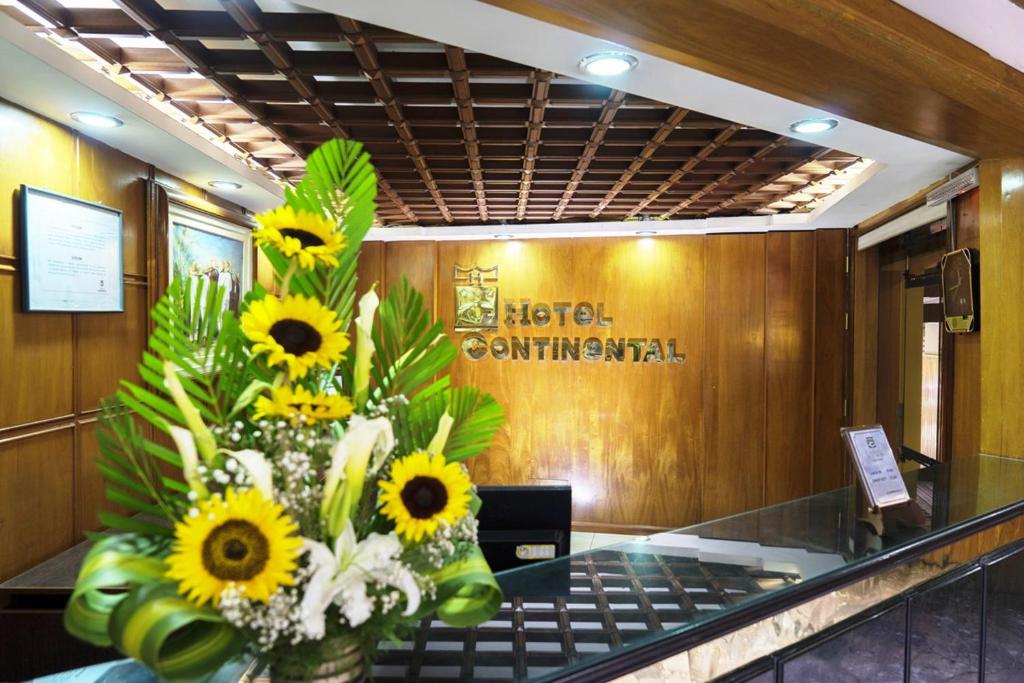 a vase filled with sunflowers sitting in a lobby at Hotel Continental (Cajamarca) in Cajamarca