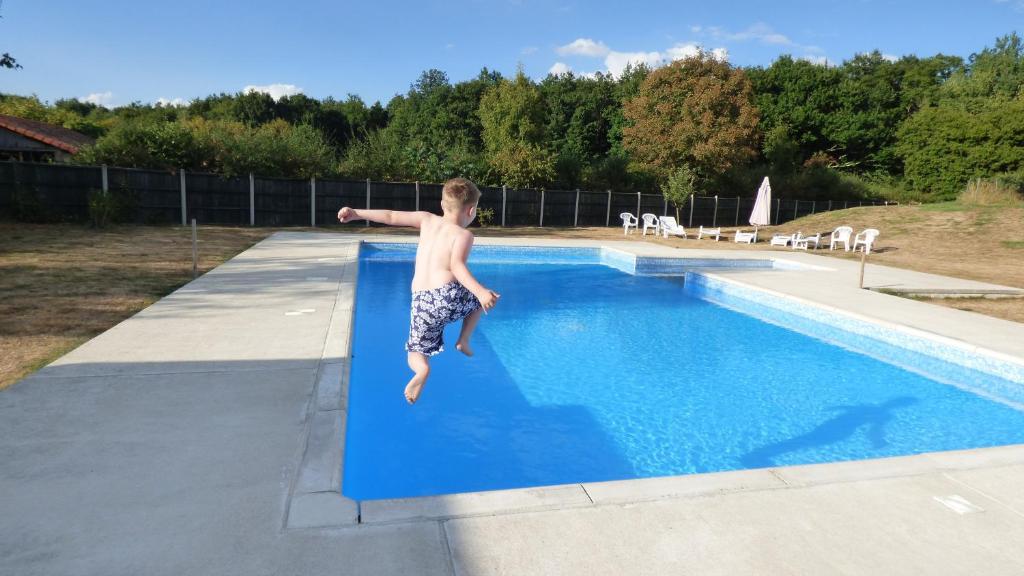 a young boy jumping into a swimming pool at ASpace Holidays in Parthenay