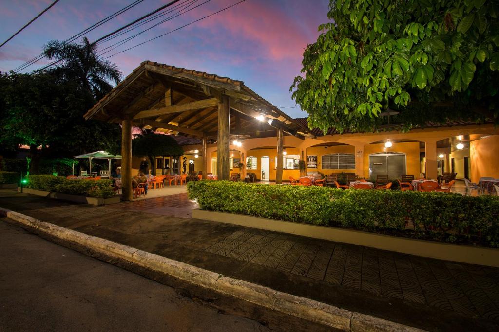 a building with a patio with tables and chairs at night at Pantanal Hotel in Miranda
