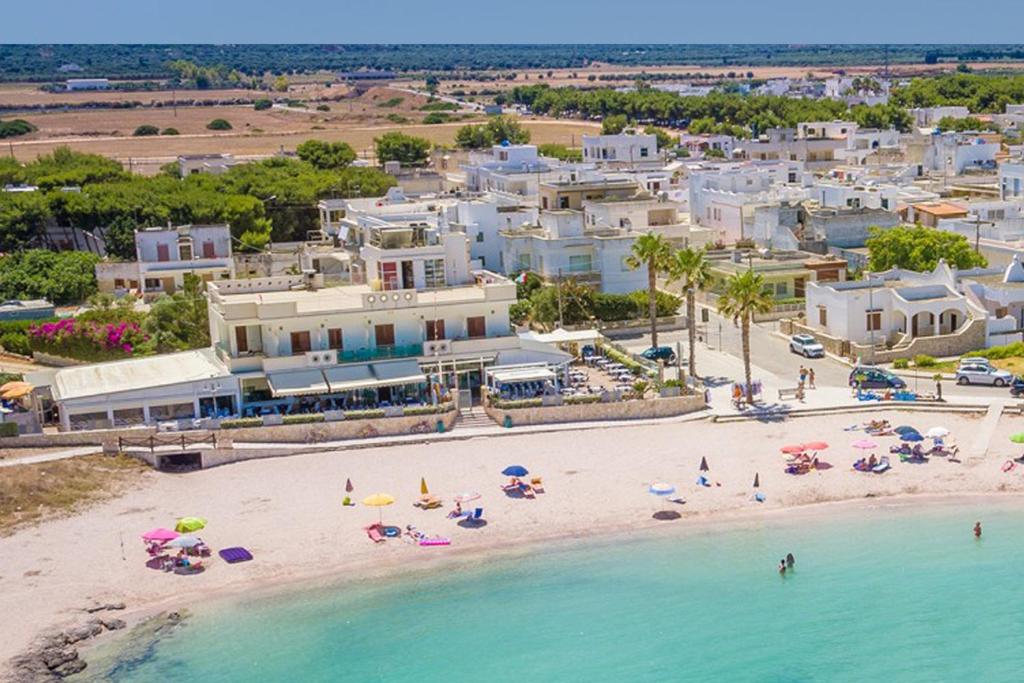 una vista aerea su una spiaggia con sedie e ombrelloni di Hotel Mirage a Torre Santa Sabina
