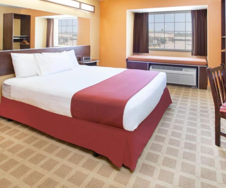 a hotel room with a large bed and a window at Microtel Inn by Wyndham Stillwater in Stillwater