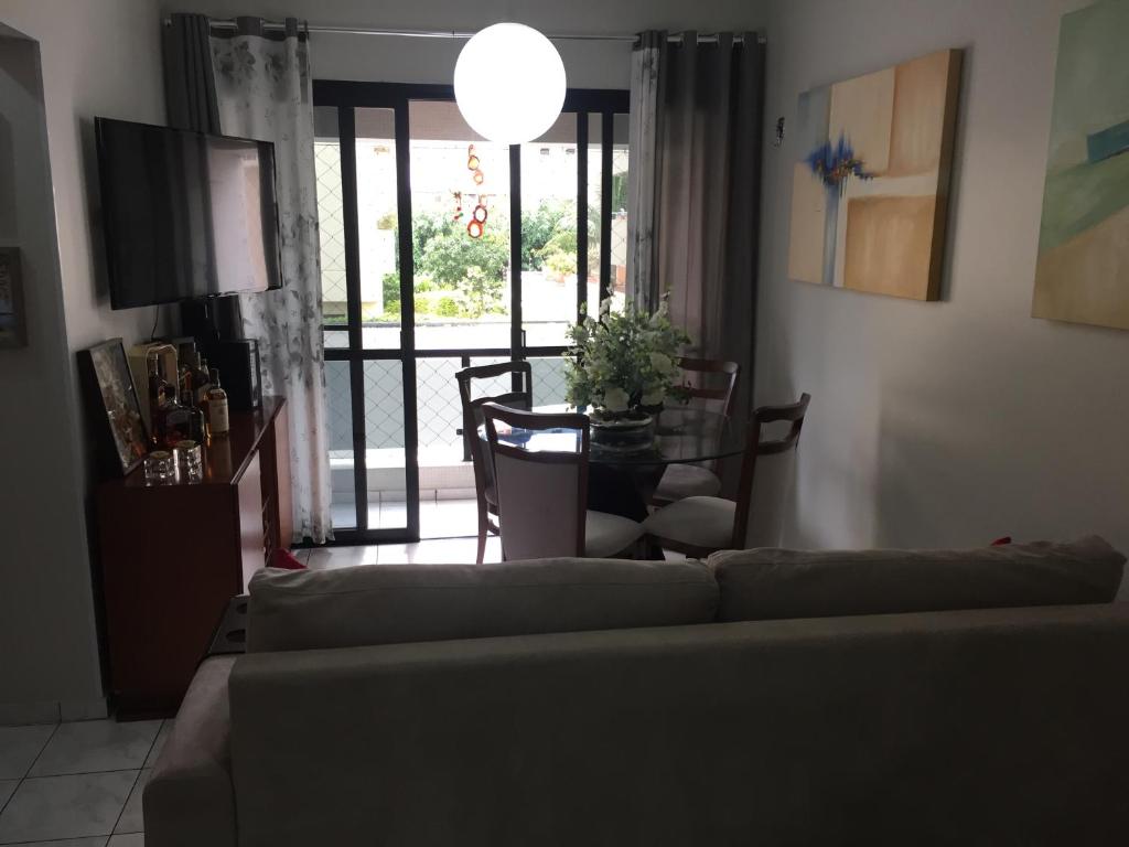 sala de estar con sofá, mesa y TV en Apartamento Maravilhoso, en Guarujá