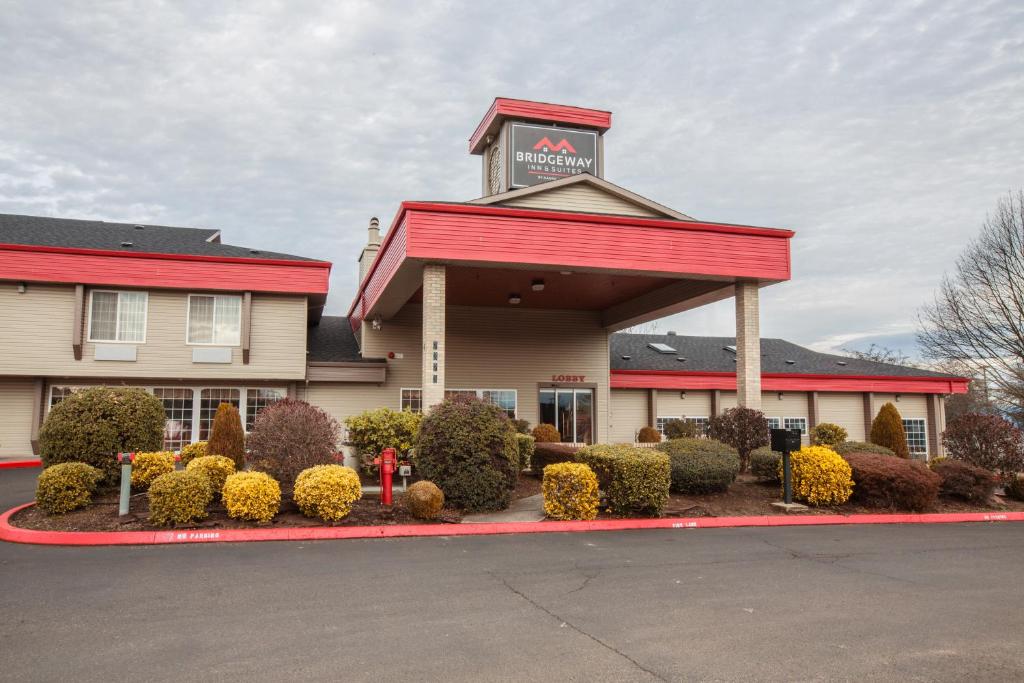 a inn with a sign on top of a building at Bridgeway Inn & Suites - Portland Airport in Gresham