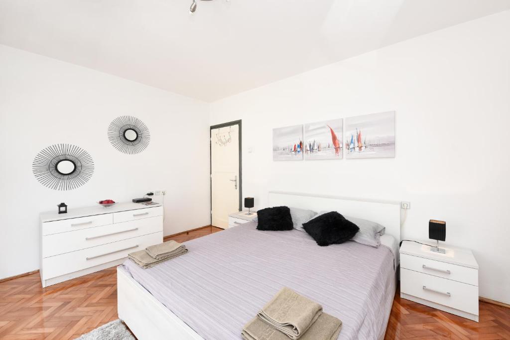 - une chambre blanche avec un grand lit et un miroir dans l'établissement Apartment Katia, à Zadar