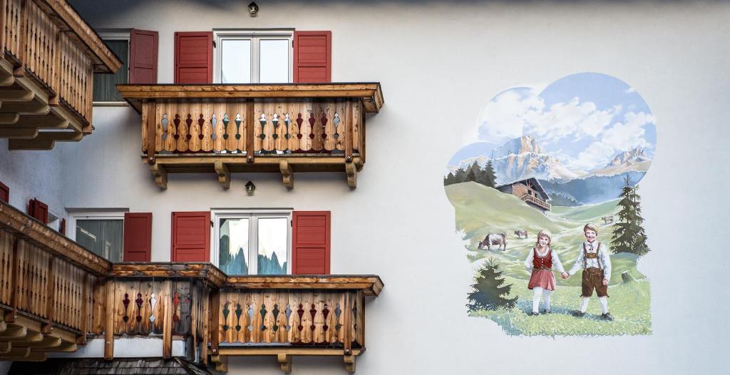un edificio con balcones y una pintura lateral en Garni Tyrolia, en Campitello di Fassa
