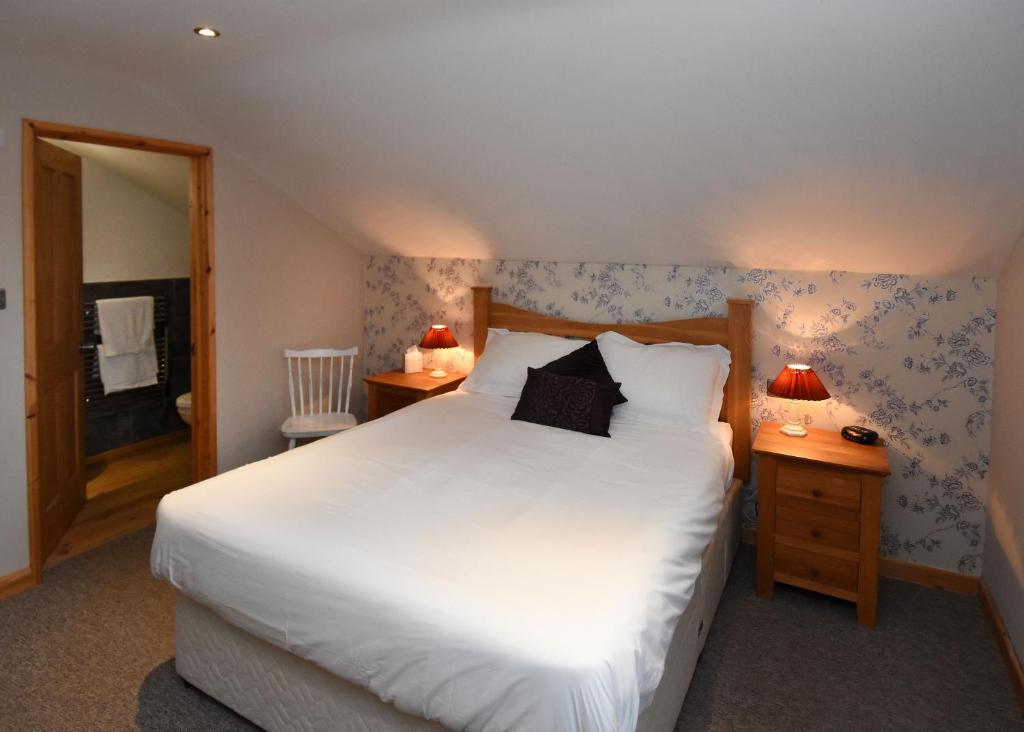 West DownにあるThe Crown Innのベッドルーム(大きな白いベッド1台、ランプ2つ付)