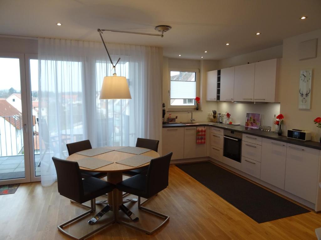 - une cuisine et une salle à manger avec une table et des chaises dans l'établissement ZISA Ferienwohnung Bodensee, à Friedrichshafen