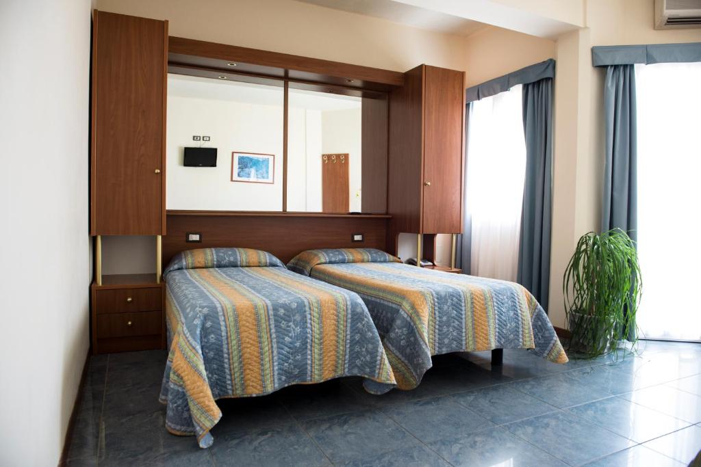 Un pat sau paturi într-o cameră la Hotel Gabbiano