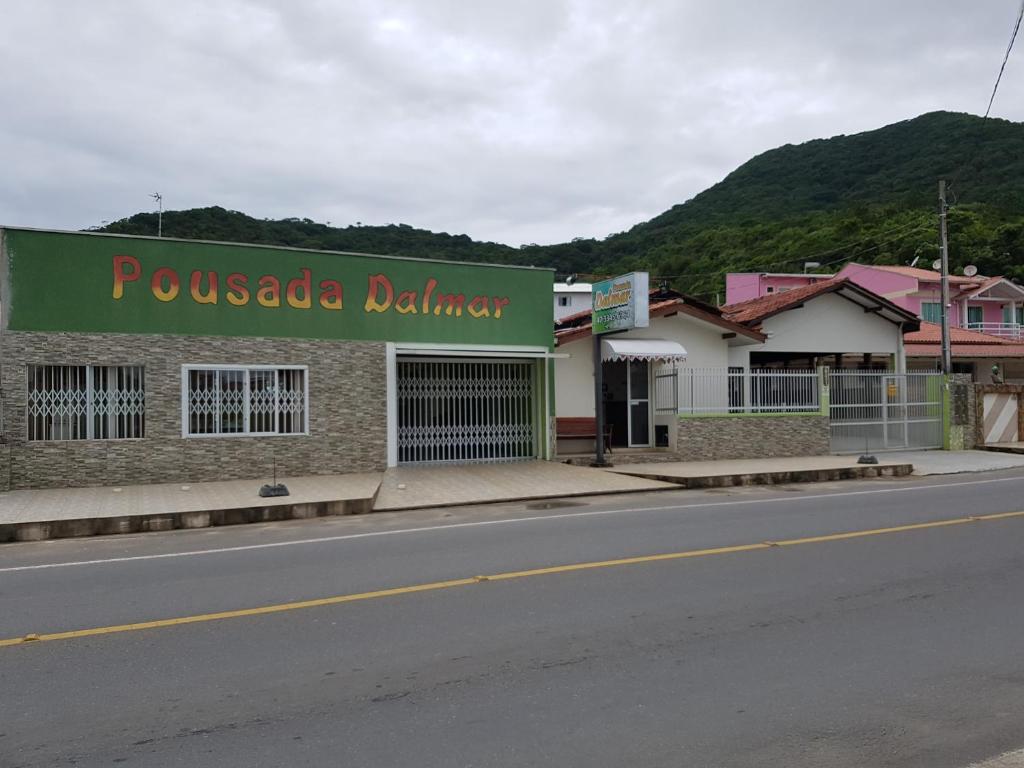 a building with a sign on the side of a road at Pousada Dalmar in Penha