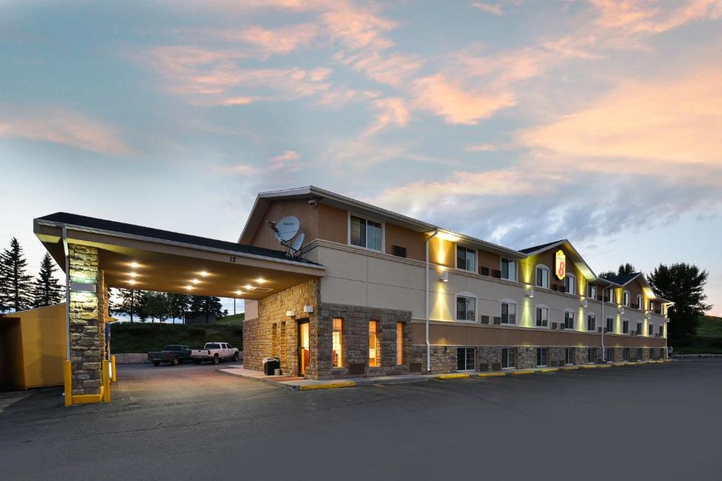 ein Gebäude mit einem Parkplatz davor in der Unterkunft Super 8 by Wyndham Minot Airport in Minot