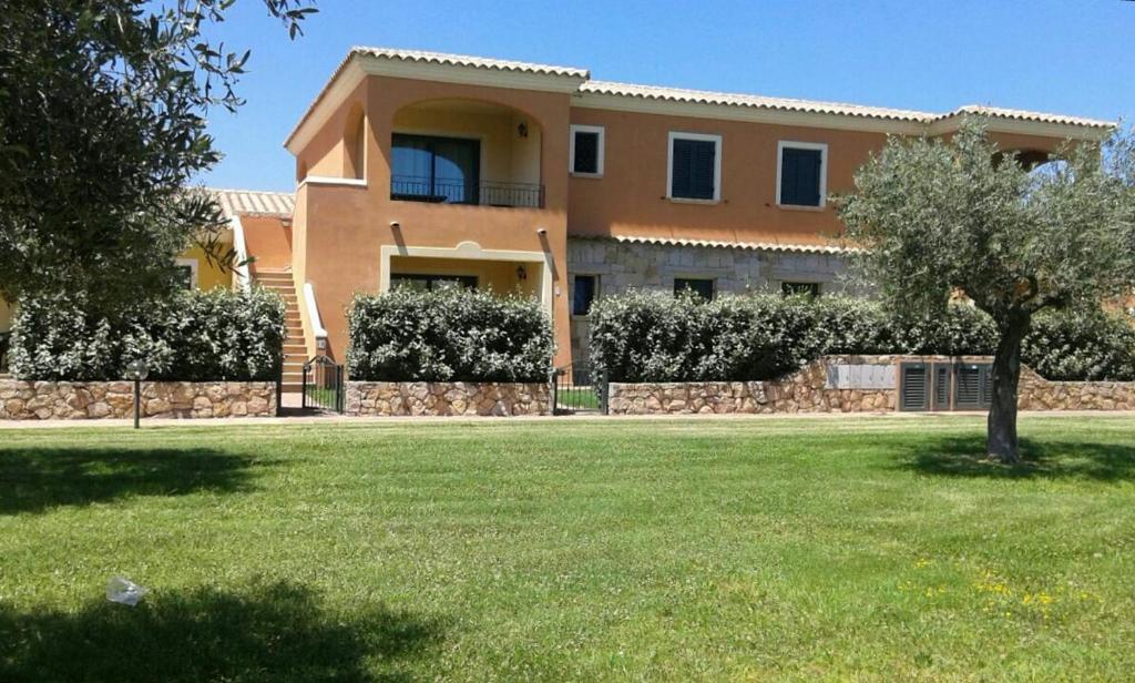 a large house with a lawn in front of it at Residence Edilmare San Teodoro in San Teodoro