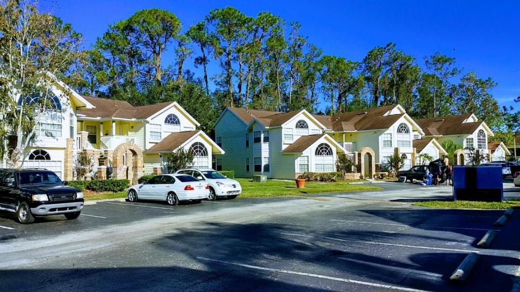 un grupo de casas con coches estacionados en un estacionamiento en Orlando House Disney Area, en Kissimmee