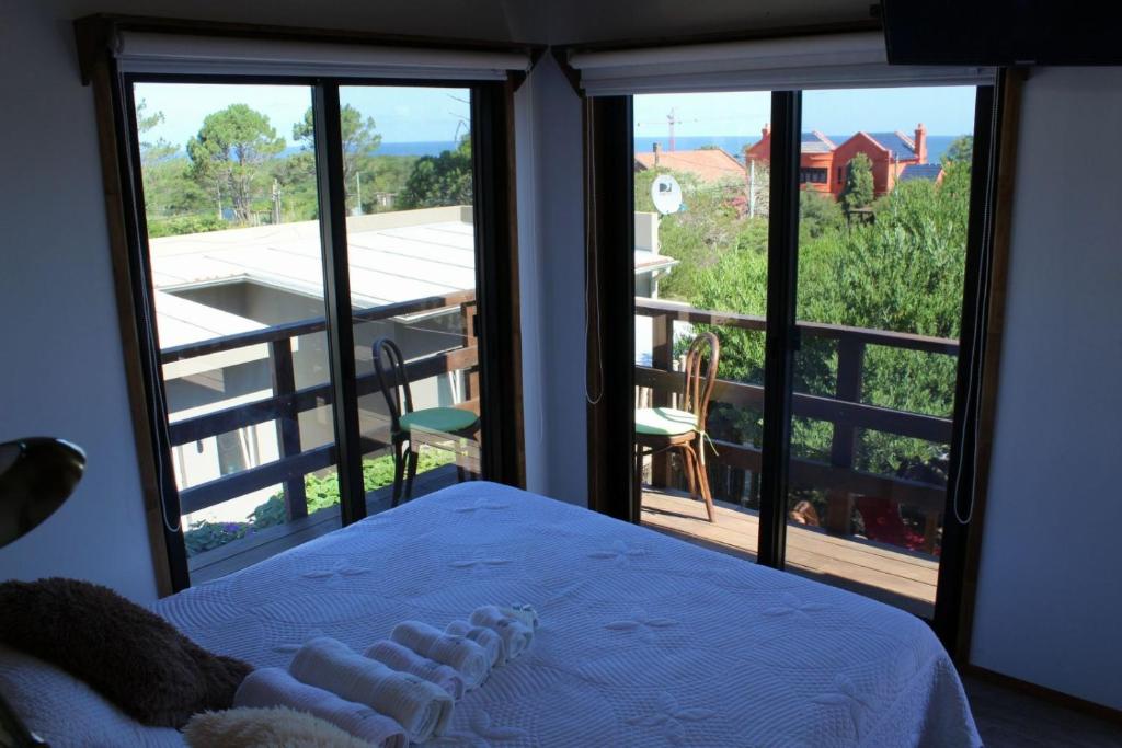 1 dormitorio con cama y vistas a un balcón en Imaginate, en Punta del Este