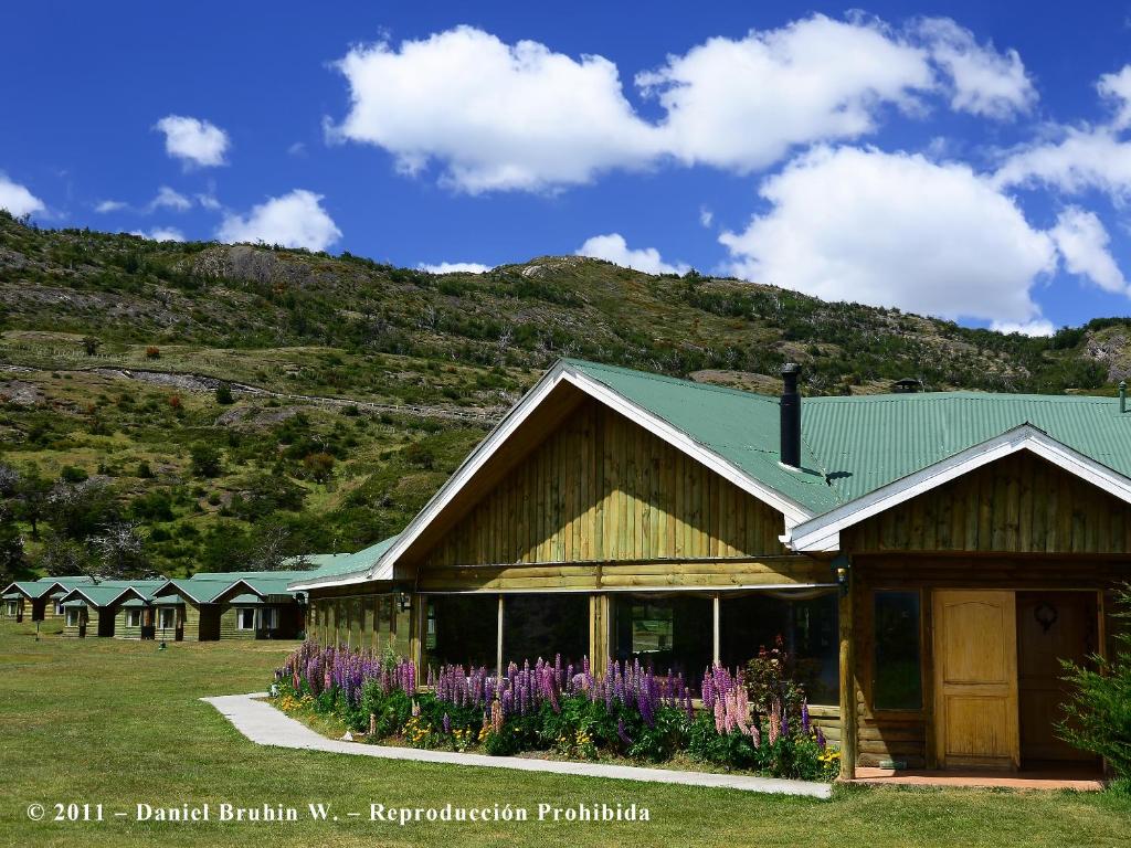 um edifício com flores roxas em frente em Hotel del Paine em Torres del Paine