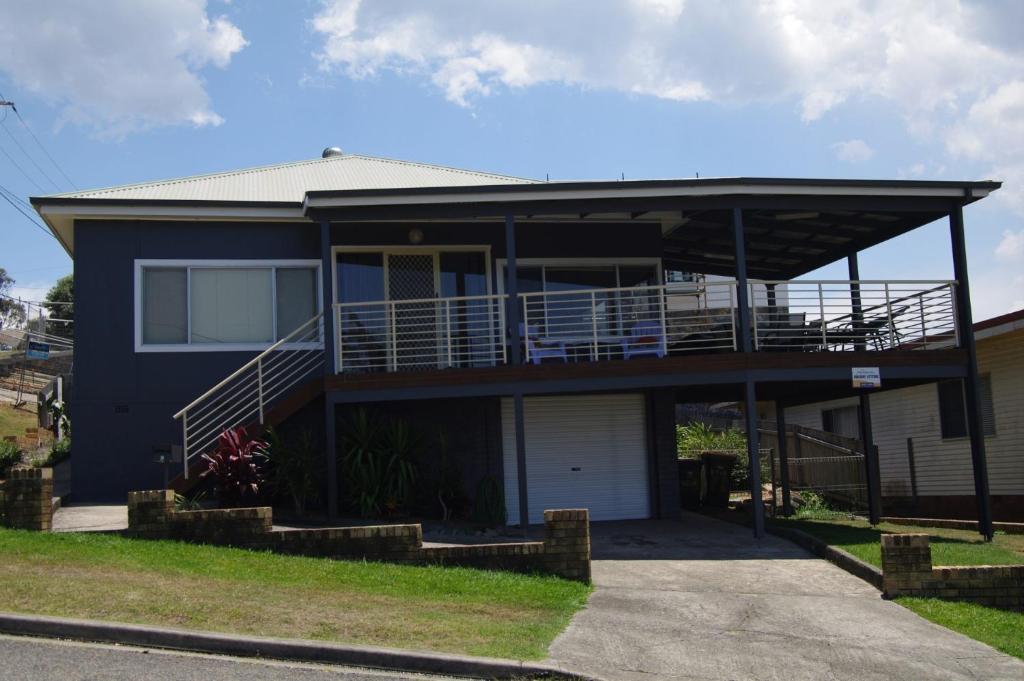 a blue house with a balcony and a driveway at Bella Vista, 9 East Street in Crescent Head
