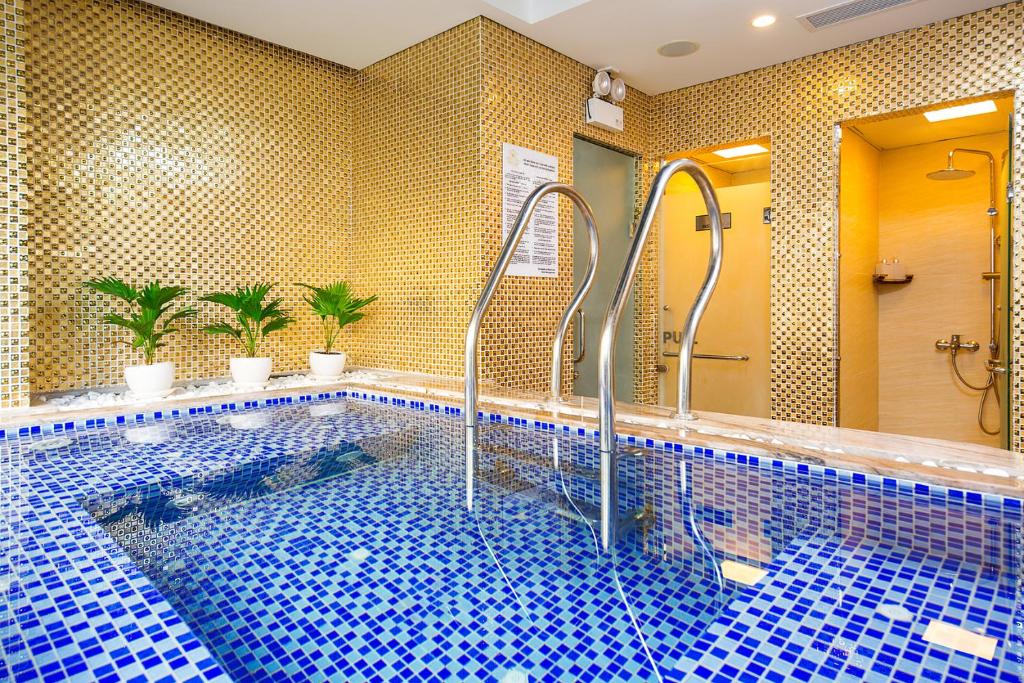 An indoor mosaic-tiled pool beside two shower rooms.