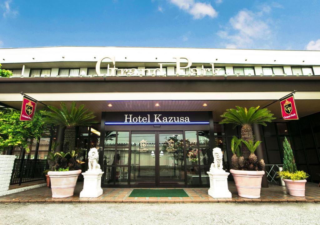 a hotel kazama with potted plants in front of it at Hotel Kazusa in Kimitsu