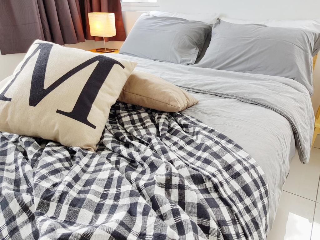 a bed with black and white sheets and pillows at No.1 The Muji @ Puchong Skypod Residence in Puchong