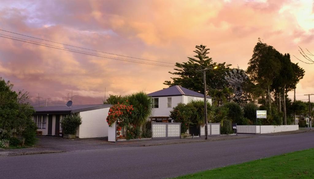 a house on a street with a cloudy sky at Westport Motels in Westport