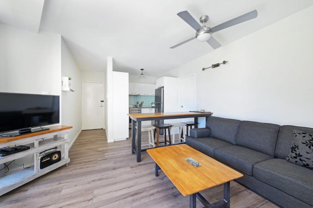 een woonkamer met een bank en een tafel bij Flynns Beach Apartments 4 41 Pacific Drive in Port Macquarie